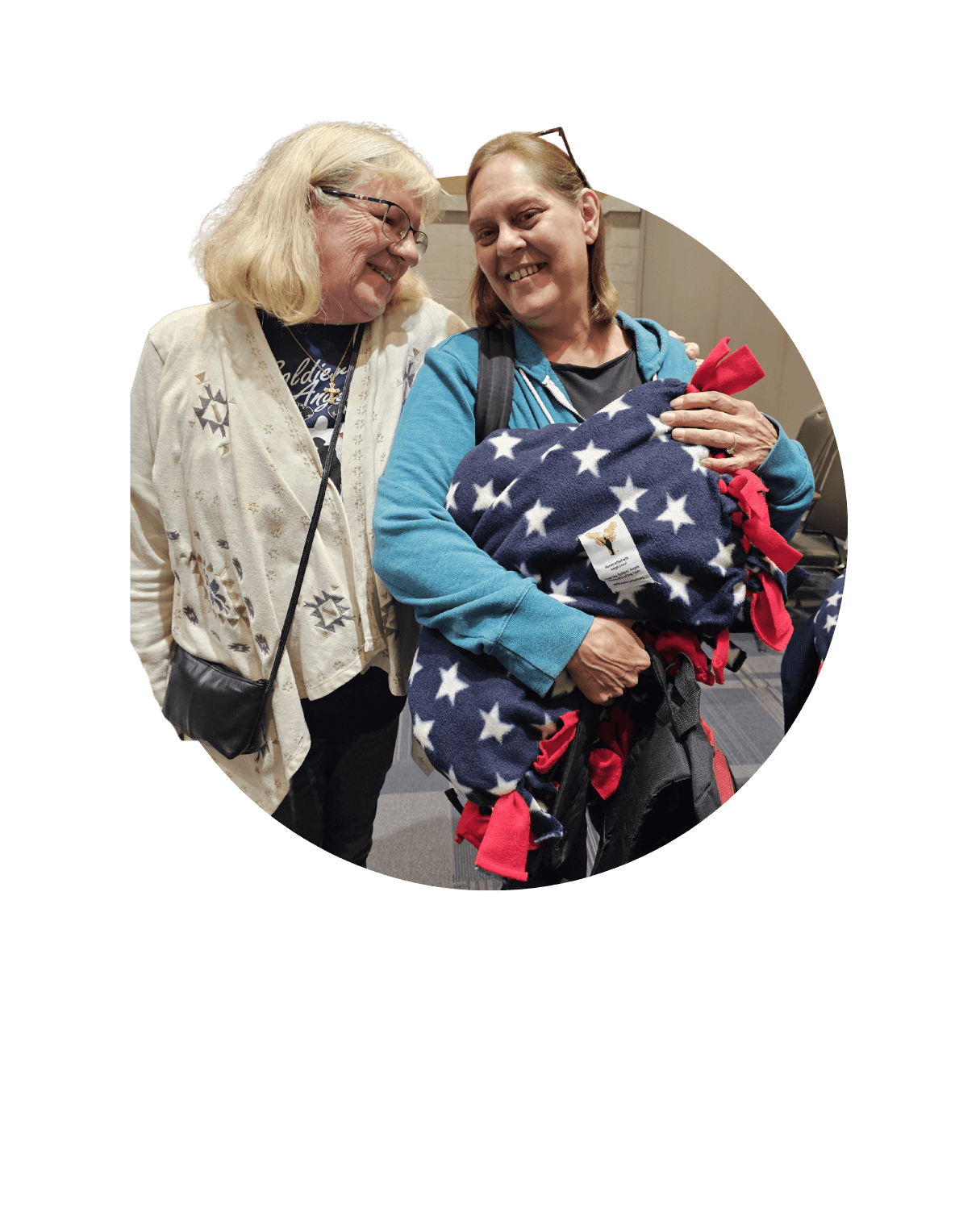 Two women hugging and smiling joyfully while taking a selfie together. 